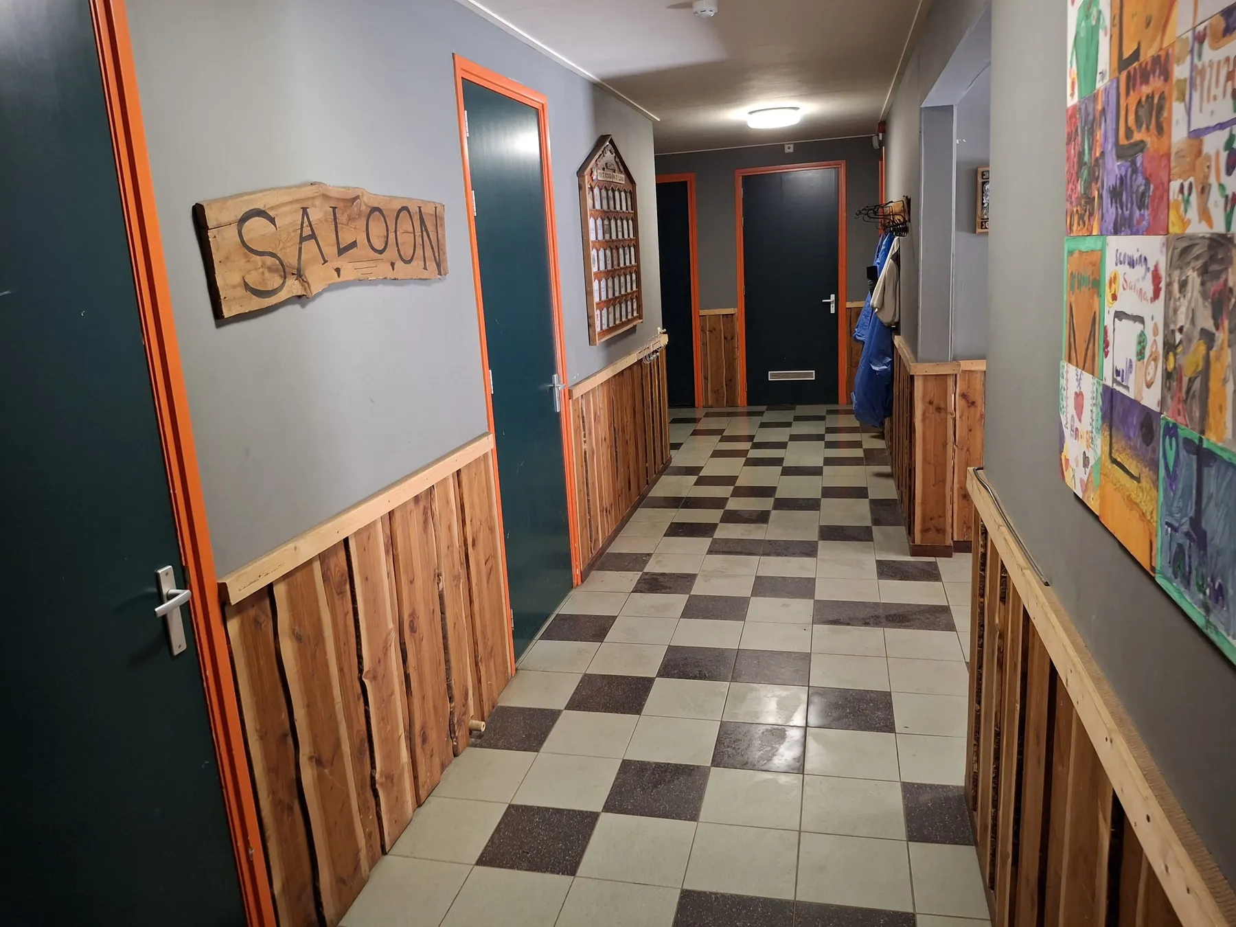 Gang met houten lambrisering en een houten bord met de tekst Saloon