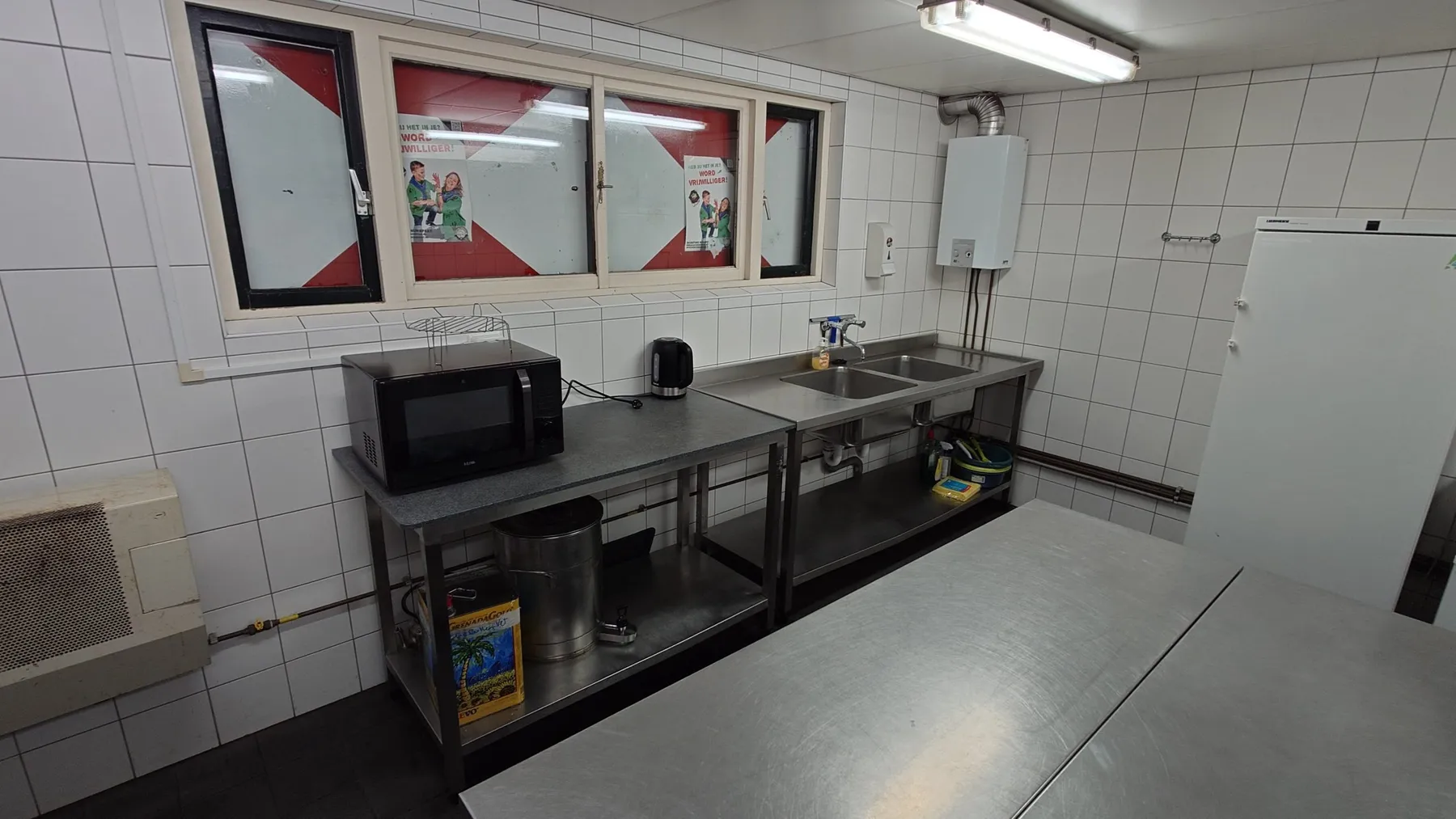 Tweede keuken met RVS aanrecht, dubbele spoelbak, magnetron en waterkoker