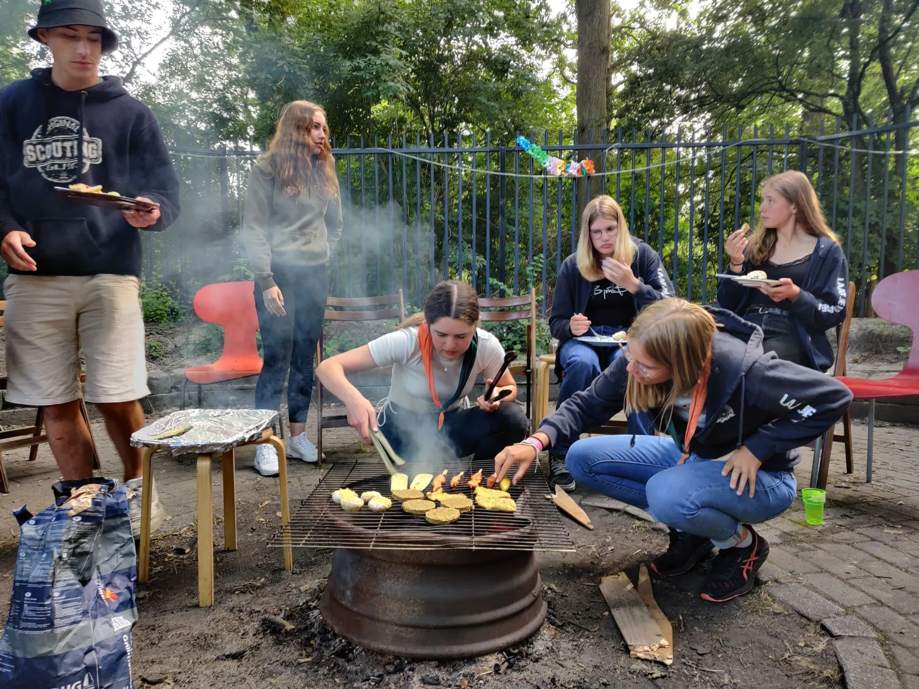 Explorers bakken maïskolven en eten op een zelfgemaakte barbecue buiten