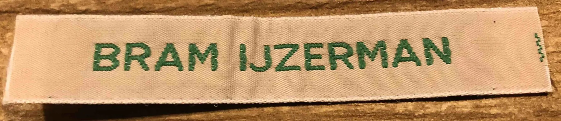 Geweven naamlint met de tekst Bram IJzerman in groene letters