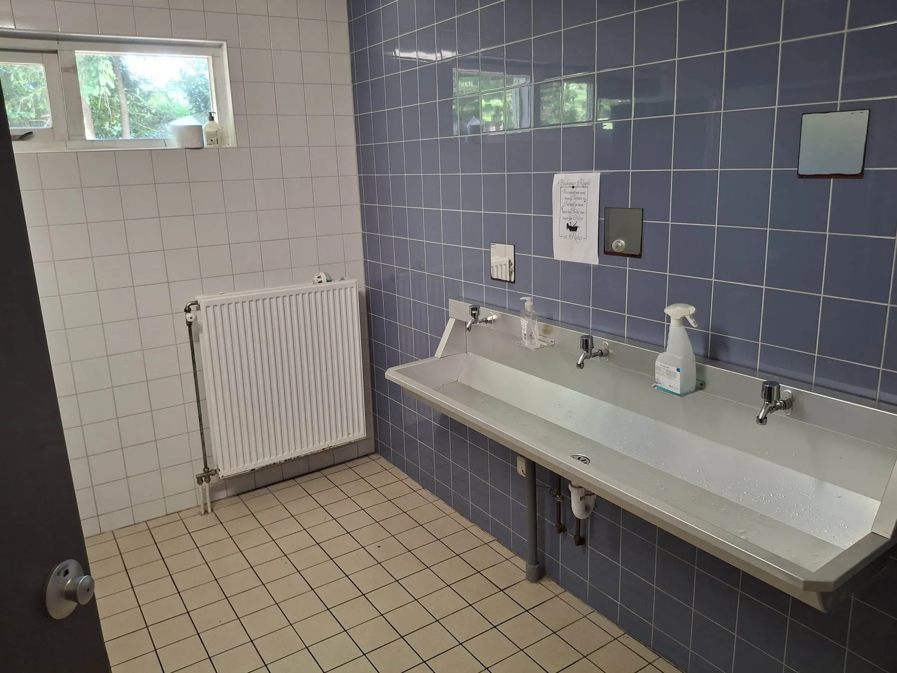 Wasruimte met een lange RVS wasbak met drie kranen